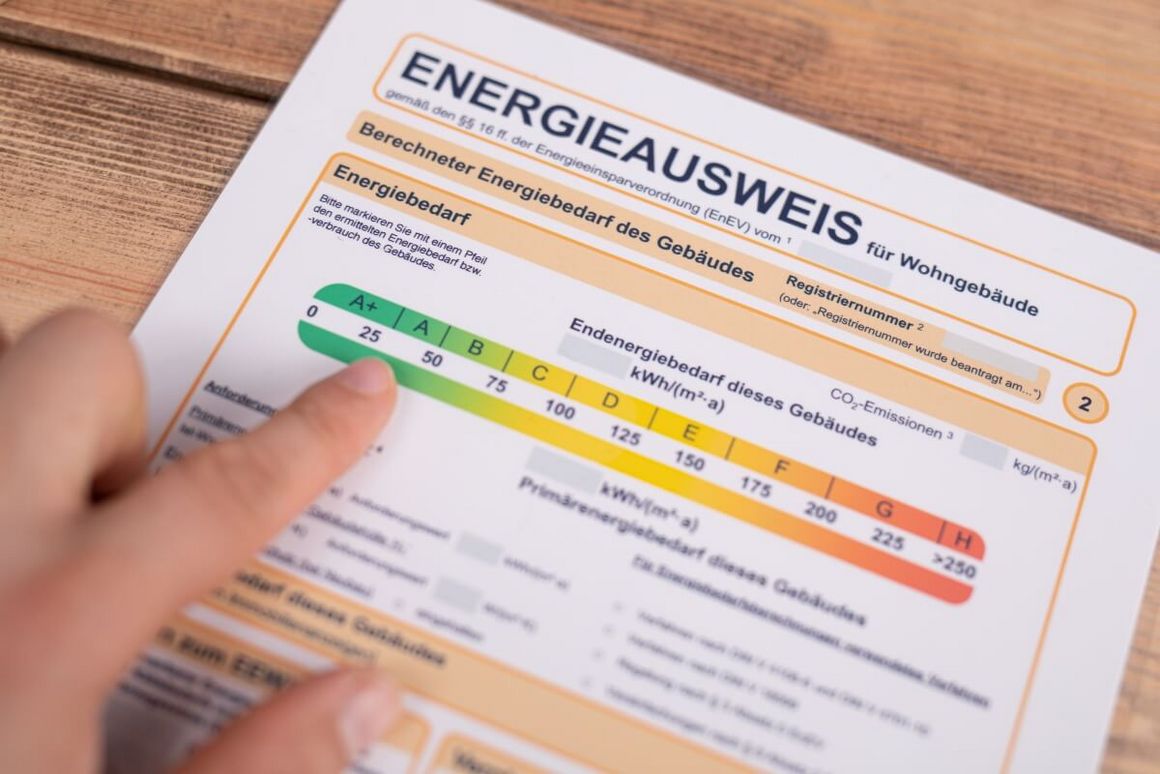 Finger zeigt auf Energieeffizienzskala auf einem Energieausweis